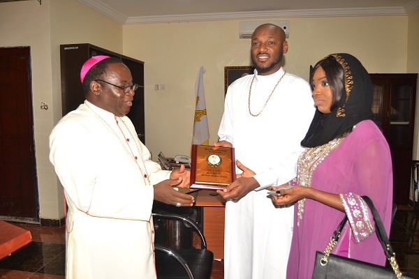 Bishop Kukah presents a plaque to TuBaba and Annie Idibia