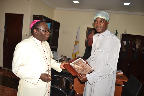 Bishop Kukah presents a plaque to Sound Sultan