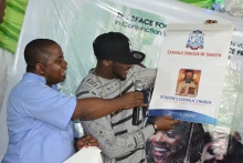Fr. Sixtus presents a calendar to TuFace